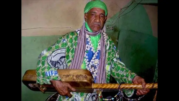 A traditional guembri resting on Moroccan fabric, with incense and candle -- ritual purity before playing